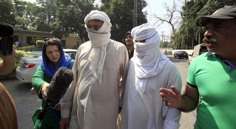 
              Father Muhammad Shahid, third from right, and ex-husband Muhammad Shakeel, second from right, of slain British-Pakistani woman Samia Shahid are chased by journalists as they arrive to appear in court in Jhelum, in eastern Pakistan, Saturday, Sept. 17, 2016. A Pakistani court on Saturday adjourned the case of Samia Shahid's murder until Sept. 23 to give police more time to submit charges against them who are accused of slaying her in the name of honor, police and lawyers said. (AP Photo/Anjum Naveed)
            