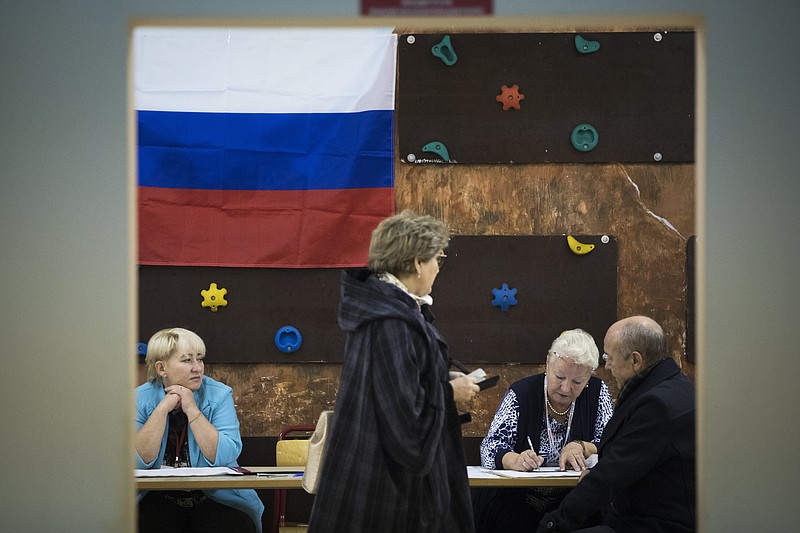 
              People register to get ballot papers at a polling station during a parliamentary elections in Moscow, Russia, Sunday, Sept. 18, 2016. Russia's weekend parliament elections take place under new rules that in principle could bring genuine opposition into the national legislature. (AP Photo/Pavel Golovkin)
            