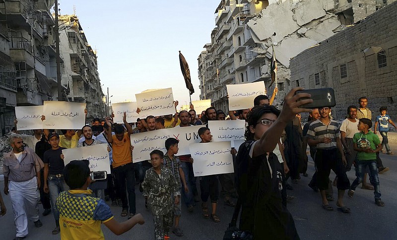 In this Sept. 13, 2016 file photo provided by Modar Shekho, activists in Syria's besieged Aleppo protest against the United Nations for what they say is its failure to lift the siege off their rebel-held area, in Aleppo, Syria. Residents in the rebel-held districts of Aleppo have a reprieve from the incessant bombings by Syrian government warplanes and the promise of an end to the crippling siege that has left produce stalls bare. (Modar Shekho via AP, File)