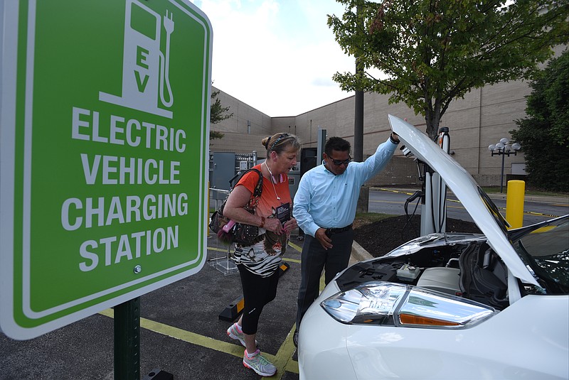 Julian Espiritu, right, shows Patricia Sager features of a car at the celebration of Chattanooga's electric vehicle car share "First Plug-In."