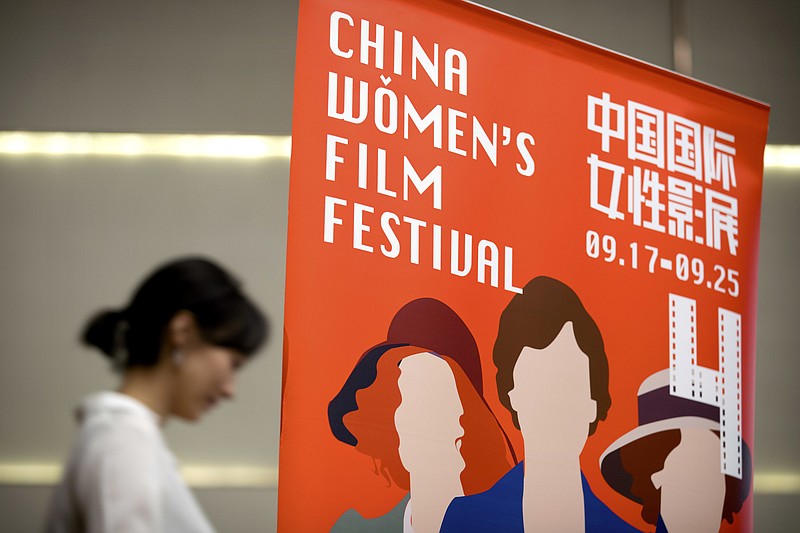 
              In this Sept. 17, 2016 photo, a participant walks past a banner for the China Women's Film Festival during its opening ceremony in Beijing. Campaigners are highlighting gender inequality in film at the China Women's Film Festival that runs until Sunday, Sept. 25 in Beijing. (AP Photo/Mark Schiefelbein)
            