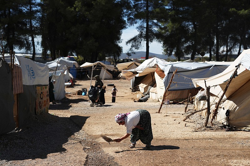 
              A woman sweeps a path among the tents at the Ritsona refugee camp north of Athens, which hosts about 600 refugees and migrants on Monday, Sept. 19, 2016. The European Union's border agency says the number of migrants arriving in the Greek islands has increased significantly over the last month. (AP Photo/Petros Giannakouris)
            