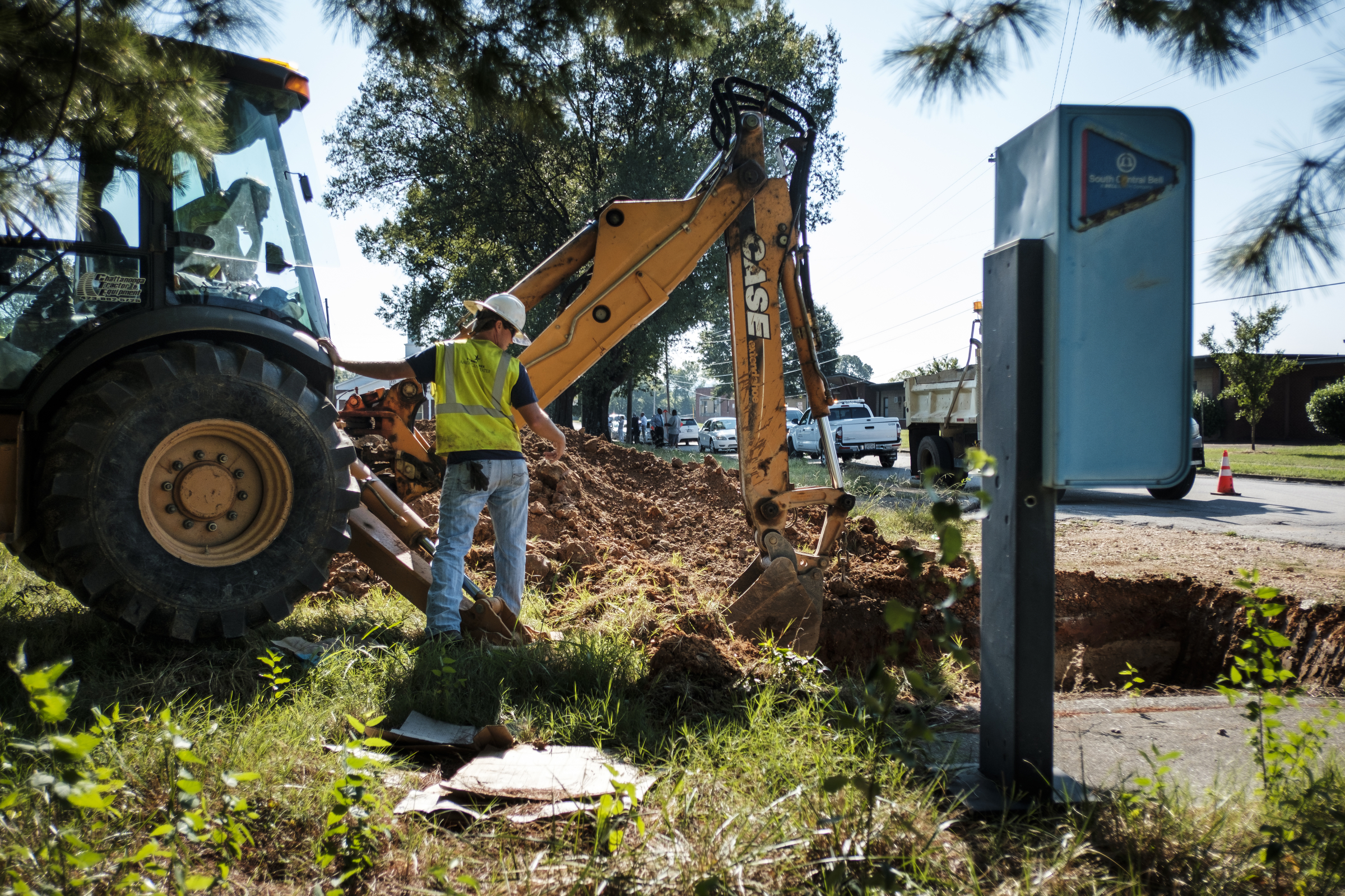 Tennessee American Water worker Drew Hixon talks to Jack Derryberry as he uses an excavator to take a water main out of service to new construction can take place at the old site of Maurice Poss Homes near Howard School on Wednesday, Sept. 21, 2016, in Chattanooga, Tenn. Officials hope to use the site to build a new stadium for Howard.