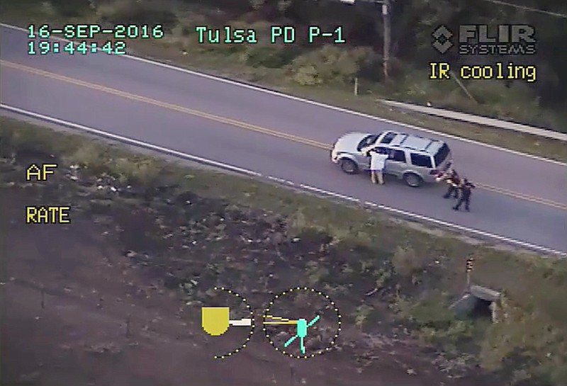 
              In this photo made from a Sept. 16, 2016 police video, Terence Crutcher, left, with his arms up is pursued by police officers as he walks next to his stalled SUV moments before he was shot and killed by one of the officers in Tulsa, Okla. When it comes to charging an officer, legal experts say, the most important determination isn't whether the officer was actually in danger in hindsight. It's whether the officer reasonably believed in his or her own mind that they or fellow officers were in danger at the split second they choose to shoot. There's no clear, standard formula investigators can rely on to answer the question of whether an officer's belief that he or she's in peril is reasonable, a former federal prosecutor in Chicago said. (Tulsa Police Department via AP)
            