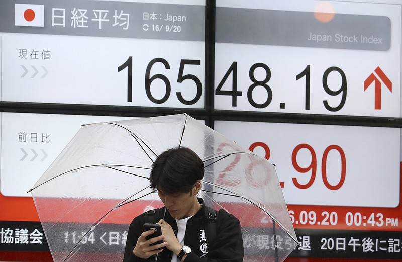 
              FILE - In this Tuesday, Sept. 20, 2016 file photo, a man stands near an electronic stock board showing Japan's Nikkei 225 index at a securities firm in Tokyo. Japan's trade balance slipped into deficit in August, for the first time in three months, as a stronger yen sapped exports, the Finance Ministry reported Wednesday, Sept. 21. (AP Photo/Eugene Hoshiko, File)
            