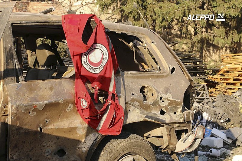 This image provided by the Syrian anti-government group Aleppo 24 news, shows a vest of the Syrian Arab Red Crescent hanging on a damaged vehicle, in Aleppo, Syria, Tuesday, Sept. 20, 2016. A U.N. humanitarian aid convoy in Syria was hit by airstrikes Monday as the Syrian military declared that a U.S.-Russian brokered cease-fire had failed, and U.N. officials reported many dead and seriously wounded.