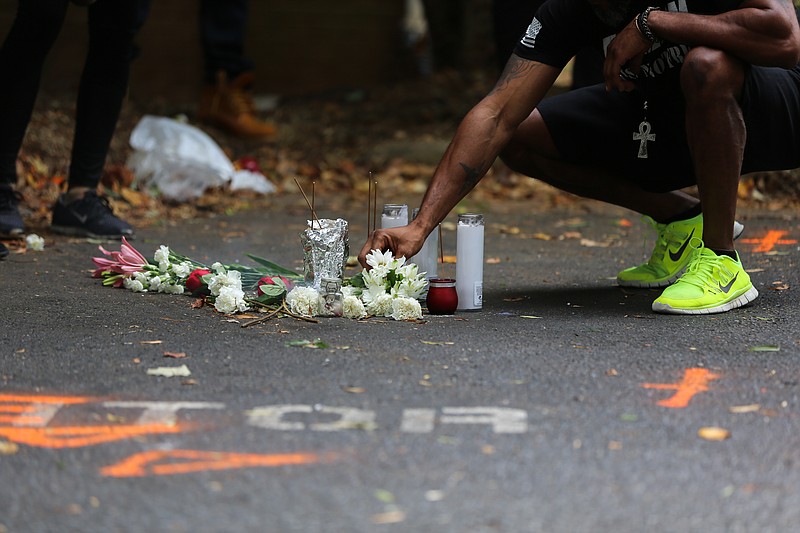 A man leaves flowers in the parking lot where Keith Scott was shot dead by a police officer in Charlotte, N.C., this week. The incident has triggered violent clashes between police and protesters. (Logan R. Cyrus/The New York Times)