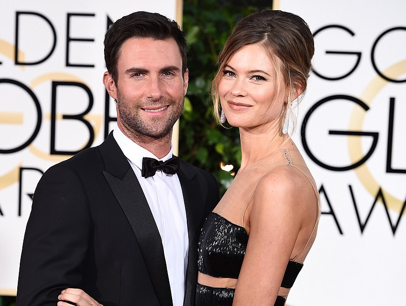 
              FILE - In this Jan. 11, 2015 file photo, Adam Levine, left, and Behati Prinsloo arrive at the 72nd annual Golden Globe Awards in Beverly Hills, Calif. A spokeswoman for "The Voice" coach says Levine and the Victoria's Secret model welcomed a daughter named Dusty Rose Levine. No other details were provided. The frontman for the band Maroon 5 and Prinsloo have been married since 2014. (Photo by Jordan Strauss/Invision/AP, File)
            