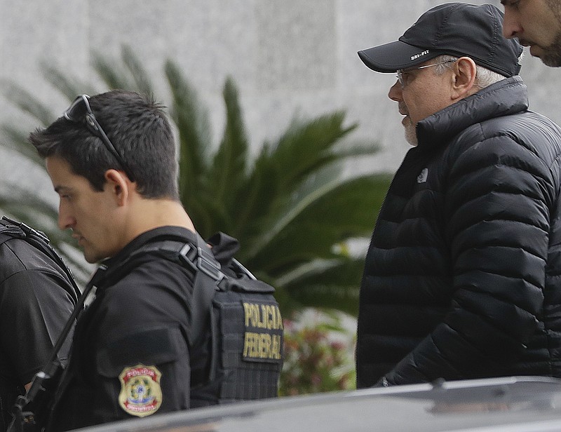 
              Former Brazilian Finance Minister Guido Mantega, right, is escorted by federal police officers, as they arrive at the Federal Police headquarters in Sao Paulo, Brazil, Thursday, Sept. 22, 2016. Mantega was arrested Thursday for investigation of alleged overpricing in the construction of oil platforms in the sprawling corruption scandal at state-run oil giant Petrobras, federal police said. (AP Photo/Andre Penner)
            