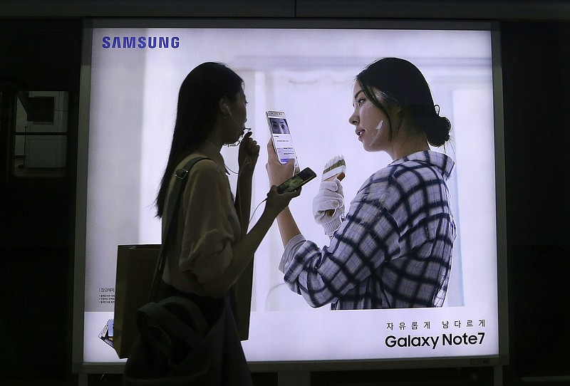 
              FILE - In this Sept. 10, 2016, file photo, a woman walks by an advertisement of the Samsung Electronics Galaxy Note 7 smartphone at a subway station in Seoul, South Korea. South Korea's government asked Samsung Electronics to extend the refund period for its Galaxy Note 7 smartphones that have been subject to an unprecedented global recall. (AP Photo/Ahn Young-joon, File)
            