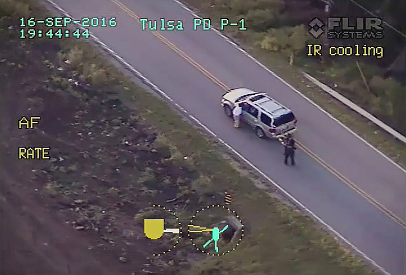 In this photo made from a Sept. 16, 2016 ,police video, Terence Crutcher, left, lowers his right arm as he is pursued by police officers moments before he was shot and killed by one of the officers in Tulsa, Okla. When it comes to charging an officer, legal experts say, the most important determination isn't whether the officer was actually in danger in hindsight. It's whether the officer reasonably believed in his or her own mind that they or fellow officers were in danger at the split second they choose to shoot. There's no clear, standard formula investigators can rely on to answer the question of whether an officer's belief that he or she's in peril is reasonable, a former federal prosecutor in Chicago said.