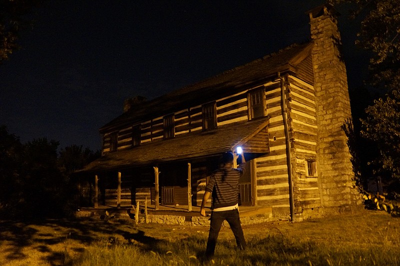 Staff writer Myron Madden stands outside Brown's Tavern, where legend says several murders were committed two centuries ago by the inn's owner, John Brown. (Staff photo by Myron Madden)