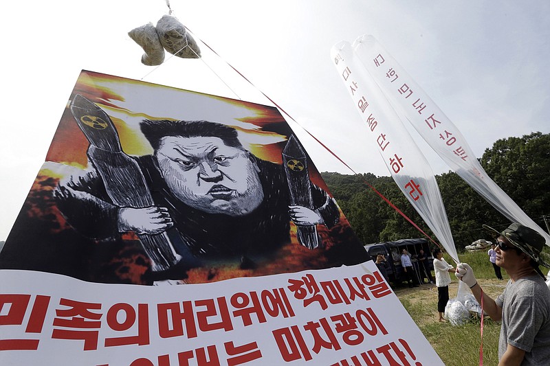 
              FILE - In this Thursday, Sept. 15, 2016, file photo, North Korean defectors prepare to release balloons carrying leaflets and a banner denouncing North Korean leader Kim Jong Un for North Korea's latest nuclear test, in Paju, near the border with North Korea, South Korea. Out of the limelight, and sometimes in secret, a small corps of former U.S. diplomats and intelligence officials, often working with academic specialists, meet regularly with high-ranking North Koreans. They discuss everything from the details of North Korea's nuclear program to the concerns on the effects of international trade sanctions on Pyongyang. (AP Photo/Ahn Young-joon, File)
            