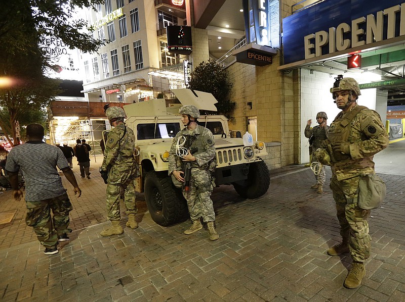 National Guardsman stand on the street in downtown Charlotte, N.C. on Thursday, Sept. 22, 2016. Charlotte police refused under mounting pressure Thursday to release video that could resolve wildly different accounts of the shooting of a black man, as the National Guard arrived to try to head off a third night of violence in this city on edge. (AP Photo/Gerry Broome)