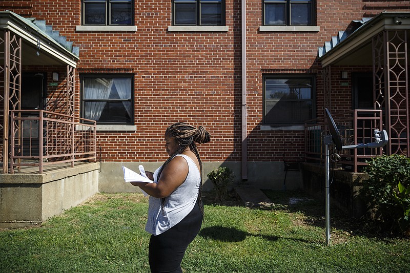 Staff photo by Doug Strickland / 
East Lake Courts resident Destiny Jones walks to deliver flyers to other residents about an infestation of rats and roaches in their apartments on Thursday, Sept. 22, 2016, in Chattanooga, Tenn. East Lake Courts residents are planning a meeting on Sunday about how to deal with the ongoing pest problem.