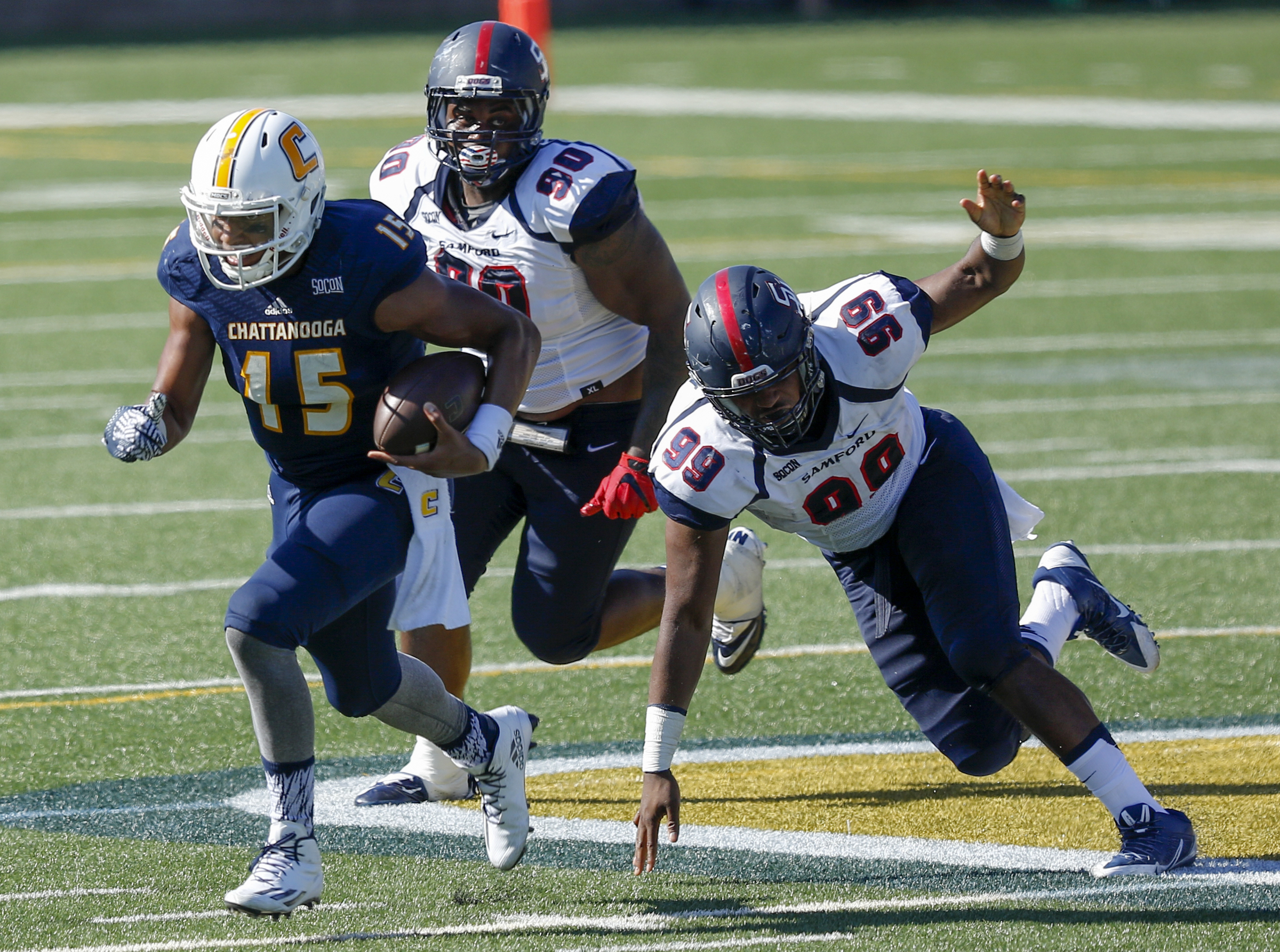 UTC quarterback Alejandro Bennifield (15) breaks away from Samford defenders Ahmad Gooden (99) and Xavier Forrest during the Mocs' home football game against the Bulldogs at Finley Stadium on Saturday, Sept. 24, 2016, in Chattanooga, Tenn.