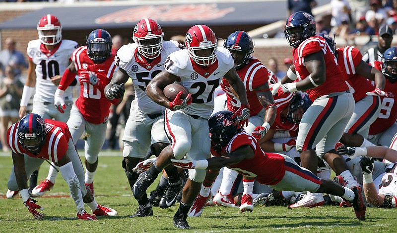 Georgia running back Nick Chubb (27) attempts to run from a surging Mississippi defense during the first half of an NCAA college football game, Saturday, Sept. 24, 2016, in Oxford, Miss. (AP Photo/Rogelio V. Solis)