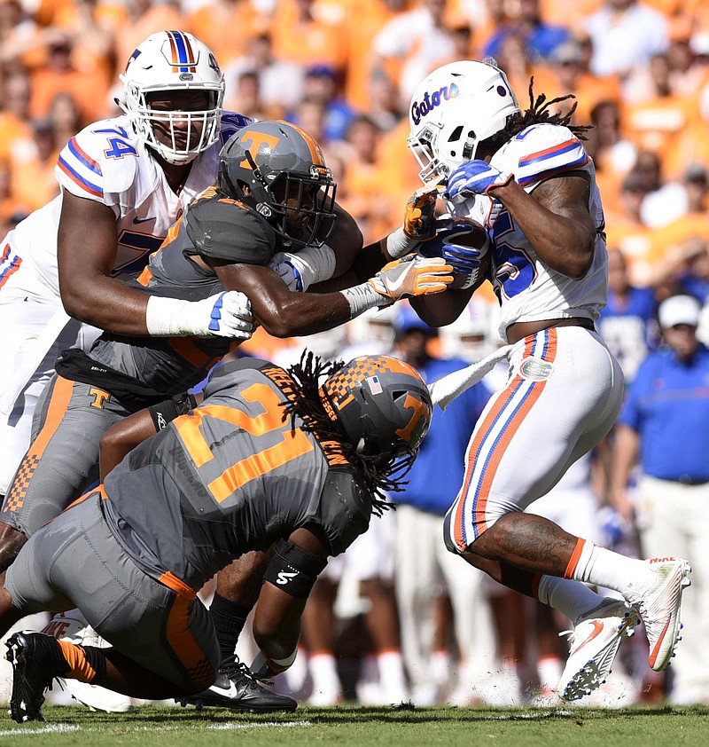 Florida's Jordan Scarlett (25) breaks the tackle of Tennessee's Jalen Reeves-Maybin (21) while Micah Abernathy (22) is held by Florida's Fred Johnson (74).  There was no penalty on the play.  The Florida Gators visited the Tennessee Volunteers in a important SEC football contest at Neyland Stadium on September 24, 2016.