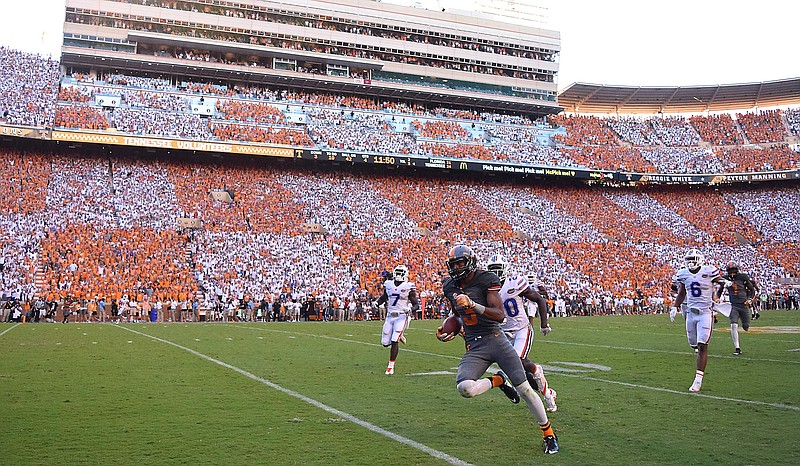 With Neyland Stadium adorned in a checkerboard pattern, Josh Malone (3) races to a fourth-quarter touchdown for Tennessee on Saturday. The Volunteers won 38-28 after trailing 21-0 to Florida, which had won the last 11 games in the series.