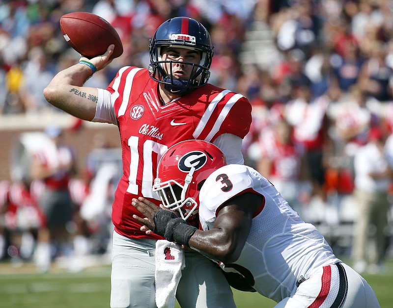 Mississippi quarterback Chad Kelly (10) manages to make a pass as he is hit by Georgia linebacker Roquan Smith (3) in the first half of their NCAA college football game, Saturday, Sept. 24, 2016, in Oxford, Miss. (AP Photo/Rogelio V. Solis)