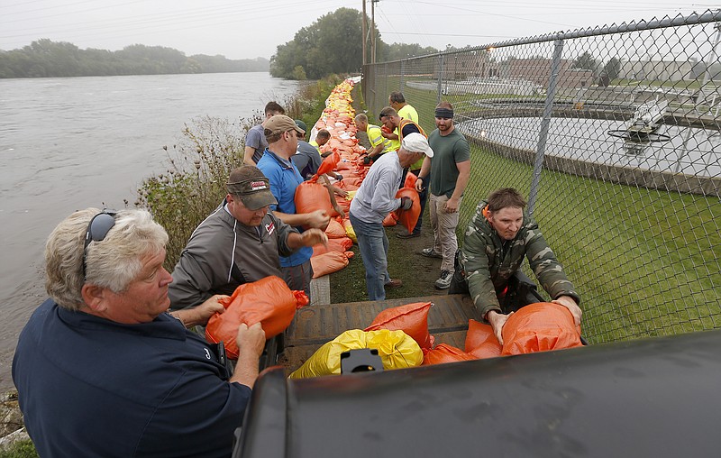 
              Volunteers and city workers place sandbags along the dike between the Cedar River and the water treatment plant in Cedar Falls, Iowa, Saturday, Sept.  24, 2016.   Authorities in several Iowa cities were mobilizing resources Friday to handle flooding from a rain-swollen river that has forced evacuations in several communities upstream, while a Wisconsin town was recovering from storms.  (Brandon Pollock/The Courier via AP)
            