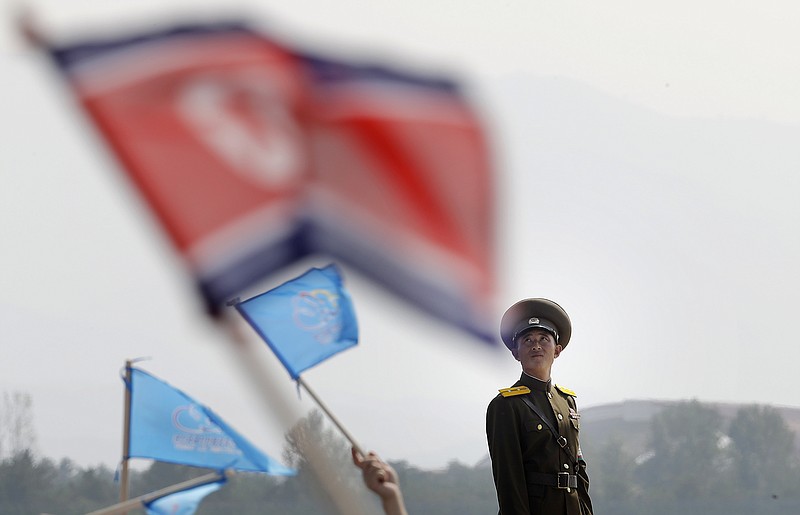 
              A North Korean military soldier stands guard as North Koreans wave flags and cheer during an aerial display on Saturday, Sept. 24, 2016, in Wonsan, North Korea. North Korea on Saturday opened an air festival featuring sky diving, demonstrations by its air force and lots of beer to promote a newly renovated and upgraded commercial airport in the coastal city of Wonsan that it hopes will draw for foreign tourists. (AP Photo/Wong Maye-E)
            