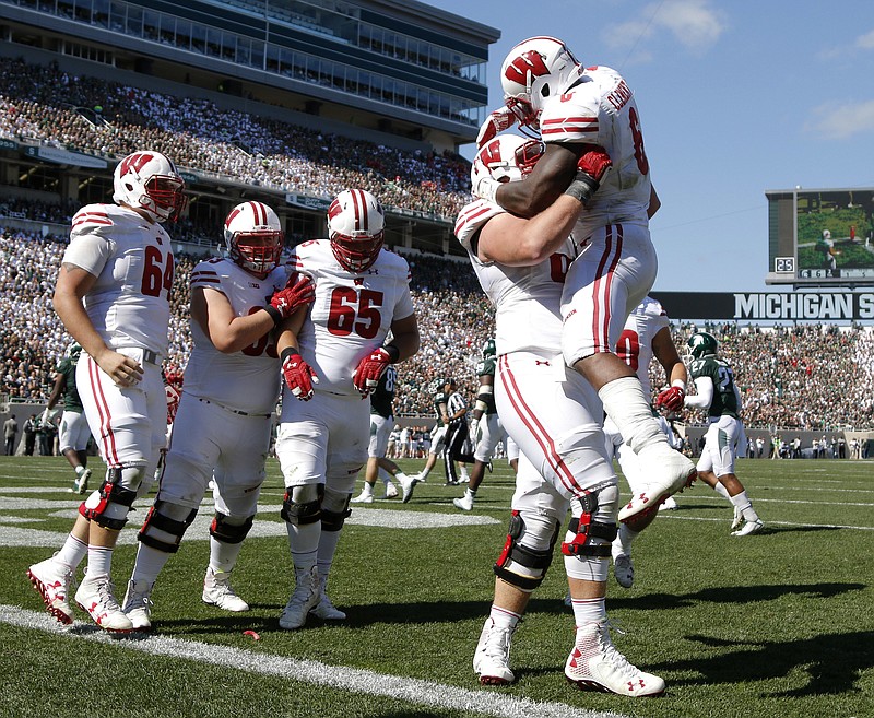 
              Wisconsin's Corey Clement, right, celebrates his touchdown against Michigan State with teammates, from left, Brett Connors, Michael Deiter, Olive Sagapolu (65) and Beau Benzschawel during the third quarter of an NCAA college football game, Saturday, Sept. 24, 2016, in East Lansing, Mich. Wisconsin won 30-6. (AP Photo/Al Goldis)
            