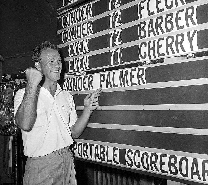 
              FILE - This June 19, 1960, file photo shows Arnold Palmer pointing to his name on the press tent scoreboard showing his four-under-par total, for 72 holes, during the National Open golf tournament at the Cherry Hills Country Club in Denver, Colo. Palmer, who made golf popular for the masses with his hard-charging style, incomparable charisma and a personal touch that made him known throughout the golf world as "The King," died Sunday, Sept. 25, 2016, in Pittsburgh. He was 87. (AP Photo/File)
            