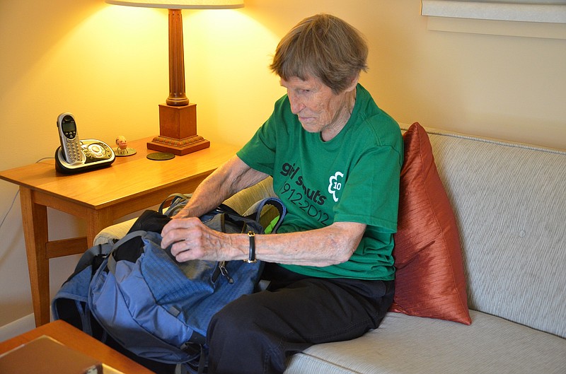Wearing a T-shirt reminding her of her long association with Girl Scouts, Jean Dolan checks her daypack in preparing for a hike.