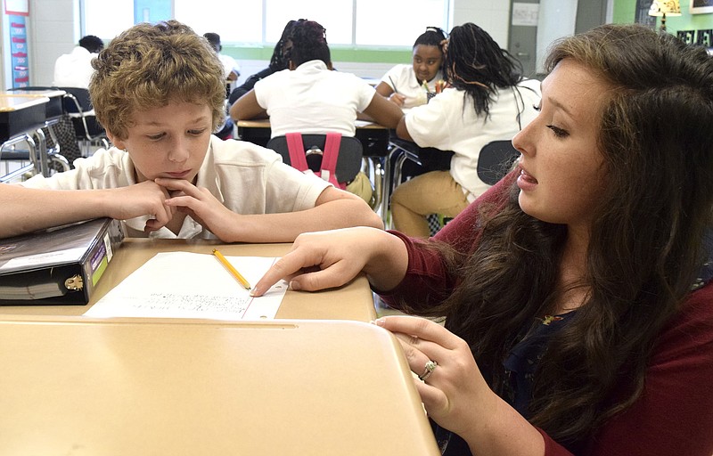 Sixth grade reading and language arts teacher Kristen Heath helps Jackie Mabe with his writing assignment at Dalewood Middle School, one of several iZone schools in Hamilton County that is working to improve test scores.