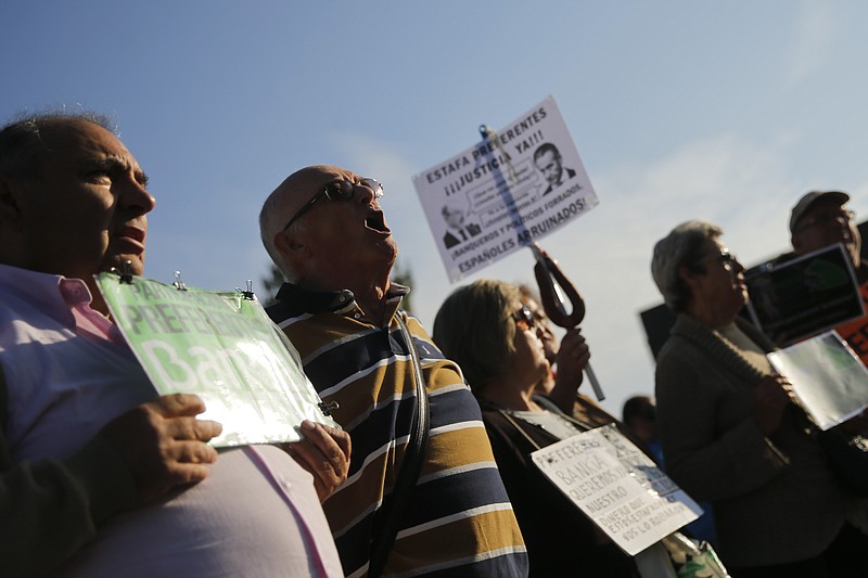 
              People protest outside the National Court as they wait for the arrival of former Finance Minister and International Monetary Fund chief Rodrigo Rato in Madrid, Monday, Sept. 26, 2016. Rodrigo Rato, and 65 officials at Bankia SA and its founding savings bank Caja Madrid, face trial for alleged misuse of corporate credit cards issued by Spain's Bankia group and its predecessor savings bank, Caja Madrid between 2003 and 2012. (AP Photo/Daniel Ochoa de Olza)
            