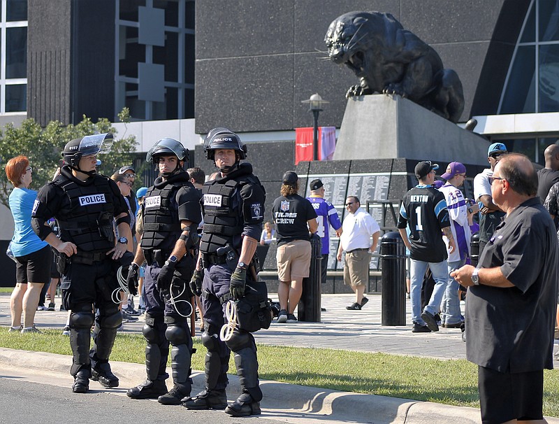 Police officers stand outside Bank of America Stadium for an NFL football game between the Minnesota Vikings and the Carolina Panthers, Sunday, Sept. 25, 2016. Extra security was posted outside the stadium in response to protests over the shooting death of a black man by a police officer on Sept. 20. (AP Photo/Skip Foreman)