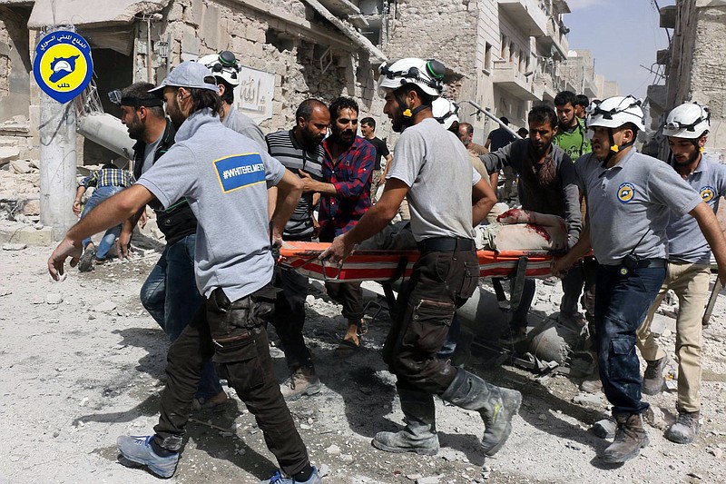 
              FILE - In this Wednesday, Sept. 21, 2016, file photo, provided by the Syrian Civil Defense White Helmets, rescue workers work the site of airstrikes in the al-Sakhour neighborhood of the rebel-held part of eastern Aleppo, Syria. Syrian Foreign Minister Walid al-Moallem said in a TV interview broadcast Monday, Sept. 26, 2016, that an internationally-brokered cease-fire for Syria is still viable, as rescue workers in Aleppo cleaned up from what they said were the worst airstrikes on rebel-held areas of the northern city in five years. Syria’s military declared the cease-fire ended one week ago. (Syrian Civil Defense White Helmets via AP, File)
            