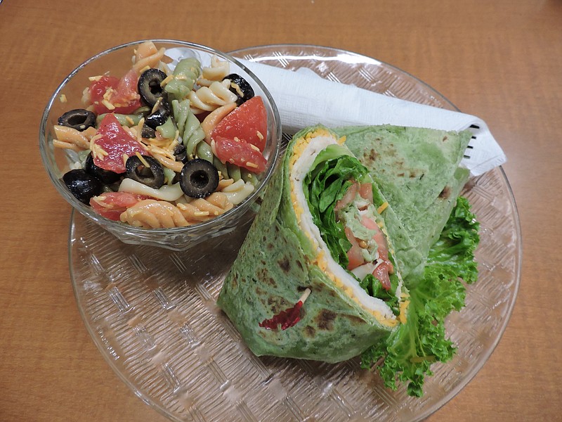 At Caffeine Addicts in downtown Ringgold, Ga., a turkey spinach wrap (only half is shown) is priced at $5, and a small pasta salad is $2.59.