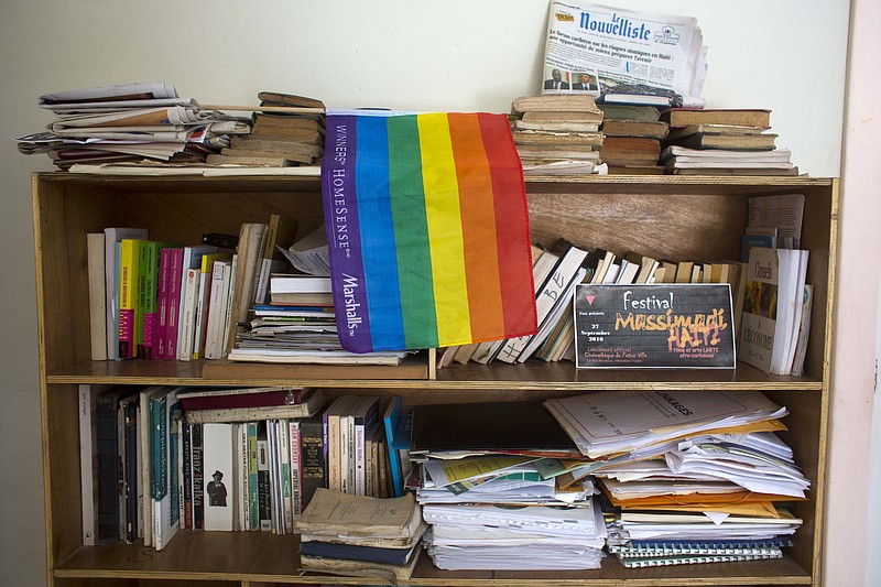 
              An LGBT pride flag hangs on a bookshelf by a Massimadi festival poster, right, at the the Kouraj organization office in Port-au-Prince, Haiti, Tuesday Sept. 27, 2016. The four-day Massimadi film, art and performance event was supposed to start Tuesday but organizers of the cultural festival celebrating Haiti’s Afro-Caribbean LGBTQ community say it has been called off due to threats of violence. (AP Photo/Dieu Nalio Chery)
            