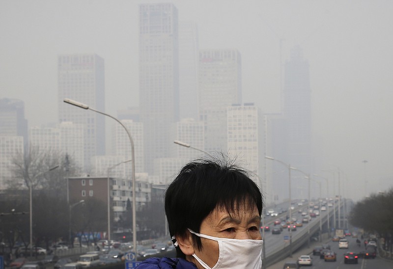 
              FILE - In this Dec. 20, 2015 file photo, a woman wearing a mask for protection against pollution walks on a pedestrian overhead bridge as office buildings are shrouded with smog in Beijing. More than nine out of 10 people worldwide live in areas with excessive air pollution, contributing to problems like strokes, heart disease and lung cancer, the World Health Organization said Tuesday, Sept. 27, 2016. The U.N. health agency said in a new report that 92 percent of people live in areas where air quality exceeds WHO limits, with southeast Asia, eastern Mediterranean and western Pacific regions hardest hit. (AP Photo/Andy Wong, File)
            