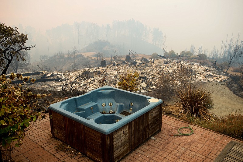 
              A hot tub rests in front of a residence leveled by the Loma fire along Loma Chiquita Road on Tuesday, Sept. 27, 2016, near Morgan Hill, Calif. More California residents were ordered from their homes Tuesday as a growing wildfire threatened remote communities in the Santa Cruz Mountains. (AP Photo/Noah Berger)
            