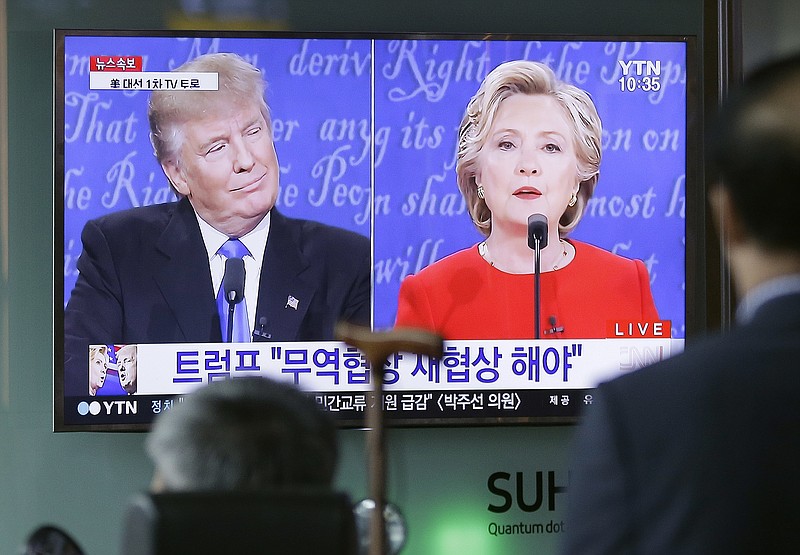 People watch a TV screen showing the live broadcast of the U.S. presidential debate between Democratic presidential nominee Hillary Clinton and Republican presidential nominee Donald Trump, at Seoul Railway Station in Seoul, South Korea, Tuesday, Sept. 27, 2016.