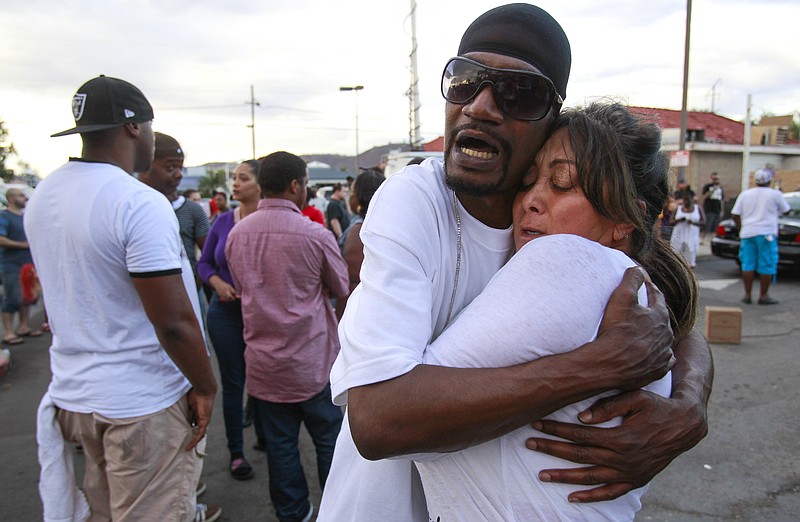 
              Shawn Letchaw hugs a woman named Marie, who didn't give her last name, at the scene where a black man was shot by police earlier in El Cajon, east of San Diego, Calif., Tuesday, Sept. 27, 2016. (Hayne Palmour IV/The San Diego Union-Tribune via AP)
            