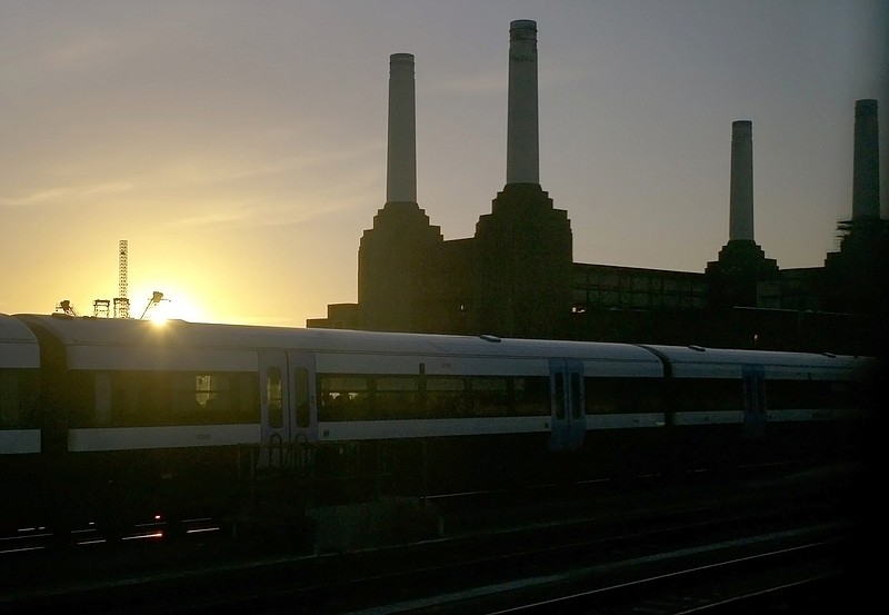 
              FILE- In this Thursday, Jan. 2, 2014 file photo, a train drives past the decommissioned Battersea power station, just after sunrise in London. Apple says it will be setting up its London headquarters in the boiler room of the Battersea Power Station, a London landmark that has long defined the skyline on the south bank of the River Thames. (AP Photo/Sang Tan, File)
            