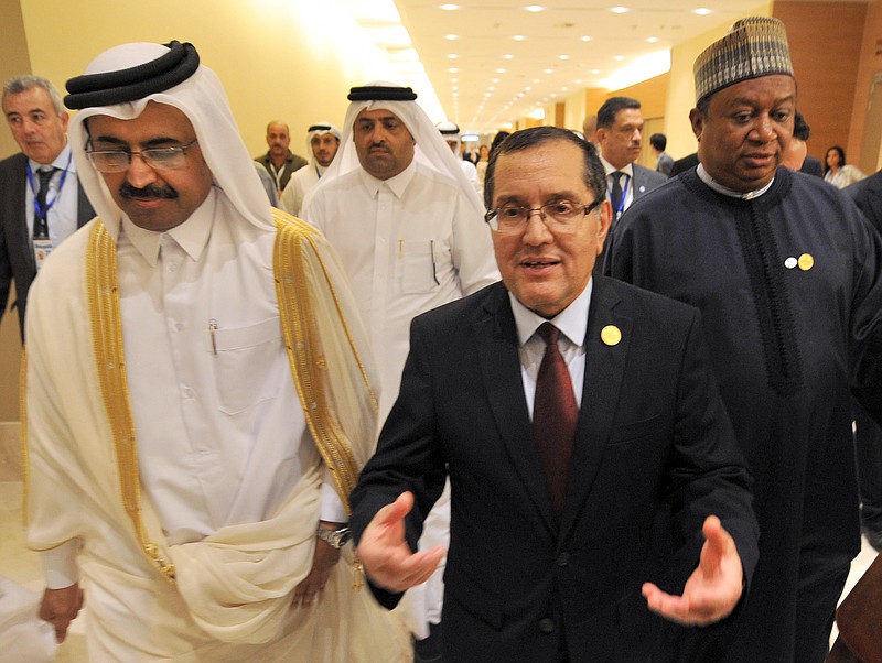 
              In this photo dated Wednesday, Sept. 28, 2016, Algerian Energy Minister Noureddine Boutarfa, center, gestures as he leaves the International Conference Center in Algiers, Algeria, with Minister of Energy and Industry of Qatar, Bin Saleh Al-Sada, left, and acting Secretary General of OPEC Mohammed Barkindo, after a meeting of oil ministers of the Organization of the Petroleum Exporting countries, OPEC, in Algiers, Algeria. OPEC nations reached a preliminary agreement Wednesday to curb oil production for the first time since the global financial crisis eight years ago, in an effort to reduce a global glut of crude that has depressed oil prices for more than two years and weakened the economies of oil-producing nations. (AP Photo/Sidali Djarboub)
            