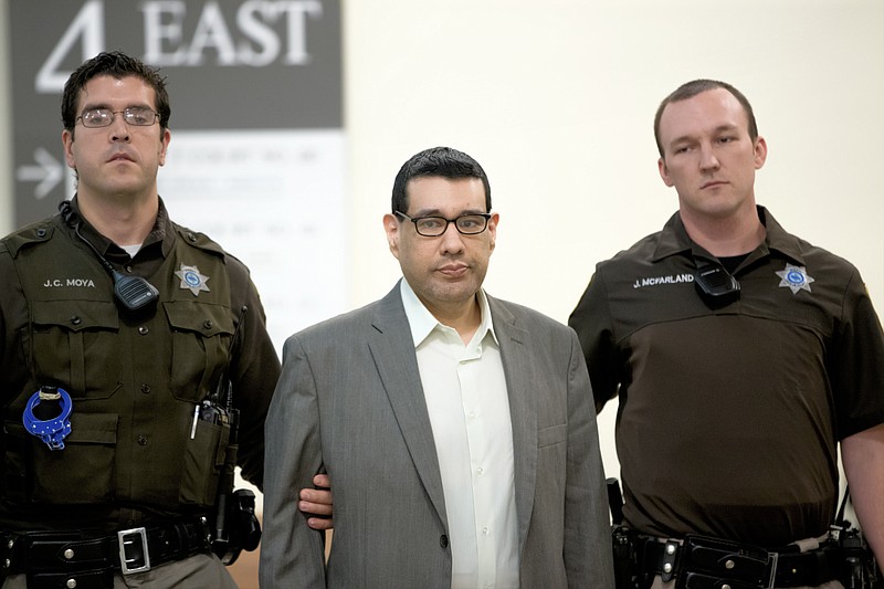 
              Anthony Garcia, center, is led by sheriff's deputies at the Douglas County Court in Omaha, Neb., Monday, Sept. 26, 2016, following a day of jury selection for his trial. Garcia, a former doctor, is accused of killing four people with ties to an Omaha medical school that fired him in 2001. (AP Photo/Nati Harnik)
            