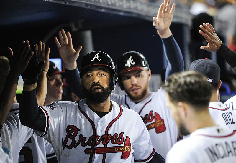 Atlanta Braves' Matt Kemp, left, and Freddie Freeman are congratulated in the dugout after Kemp's two-run home run during the fourth inning of a baseball game against the Philadelphia Phillies, Wednesday, Sept. 28, 2016, in Atlanta. (AP Photo/John Amis)