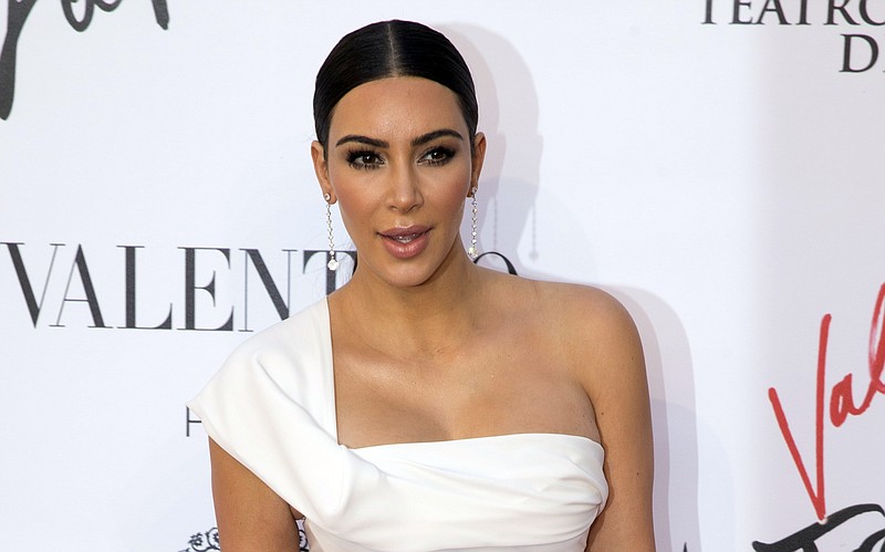 
              FILE - In this Sunday, May 22, 2016 file photo, Kim Kardashian poses for photographers as she arrives for the premiere of Verdi’s ‘’La Traviata’’ at the Rome Opera House, in Rome. Serial celebrity prankster Vitalii Sediuk has struck again, this time at Paris Fashion Week, targeting Kim Kardashian’s derriere as she was entering the L'Avenue restaurant. Kardashian’s makeup artist caught the Wednesday, Sept. 28, 2016 incident in a video that he posted to his Instagram account. It shows the reality television star negotiating her way through a crowd of paparazzi past her black car, as Sediuk, a former Ukrainian television reporter, swoops in and seems to attempt to kiss Kardashian’s posterior. (AP Photo/Andrew Medichini, file)
            