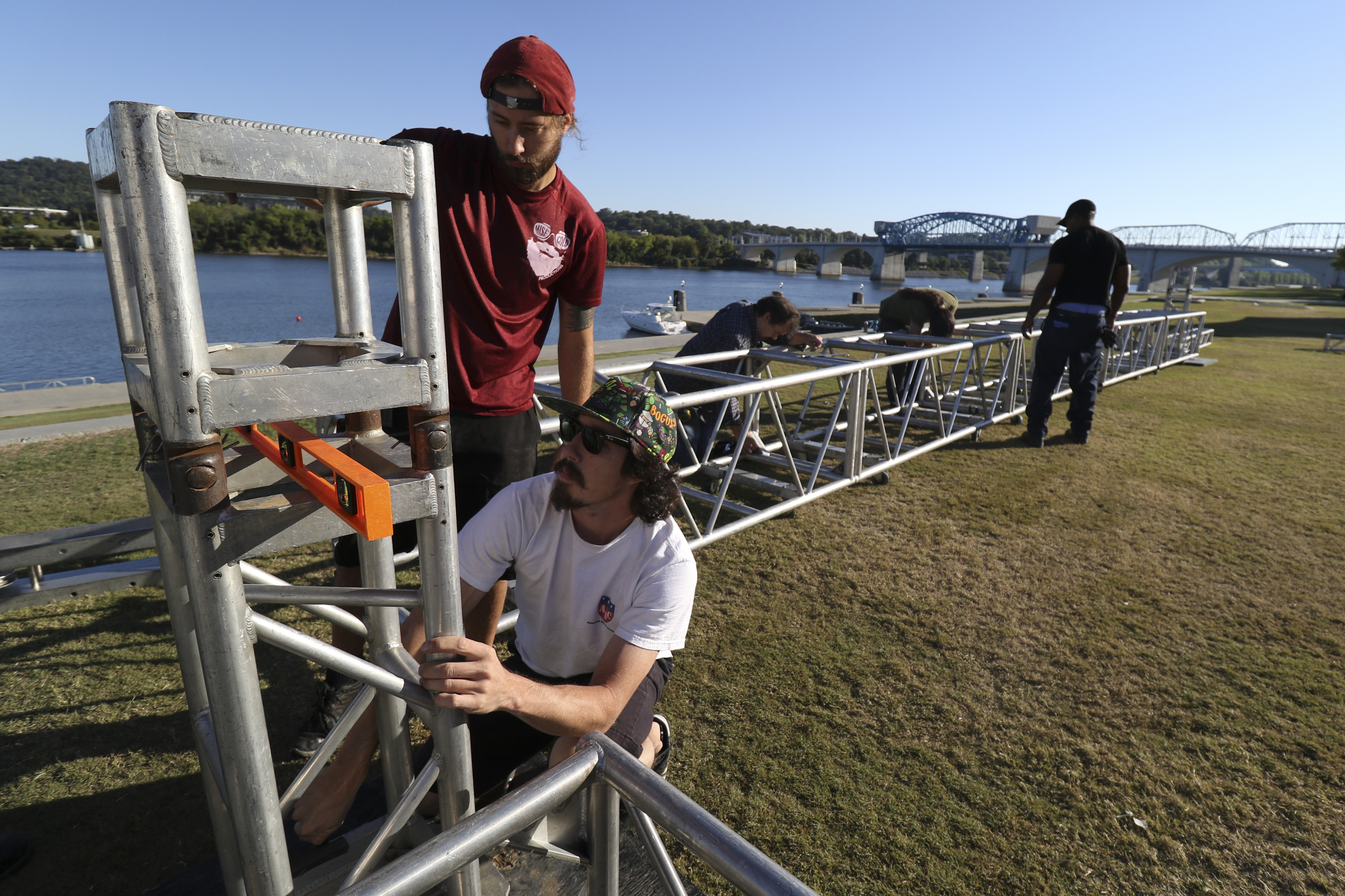 Staff Photo by Dan Henry / The Chattanooga Times Free Press- 9/29/16. Brandon Lemming, top, Travis Price, bottom, and other members of the American Stage Company, set up a 60'x20' stage on Thursday, September 29, 2016, along the riverfront in preparation for this weekend's 10th annual 3 Sisters Bluegrass Festival.