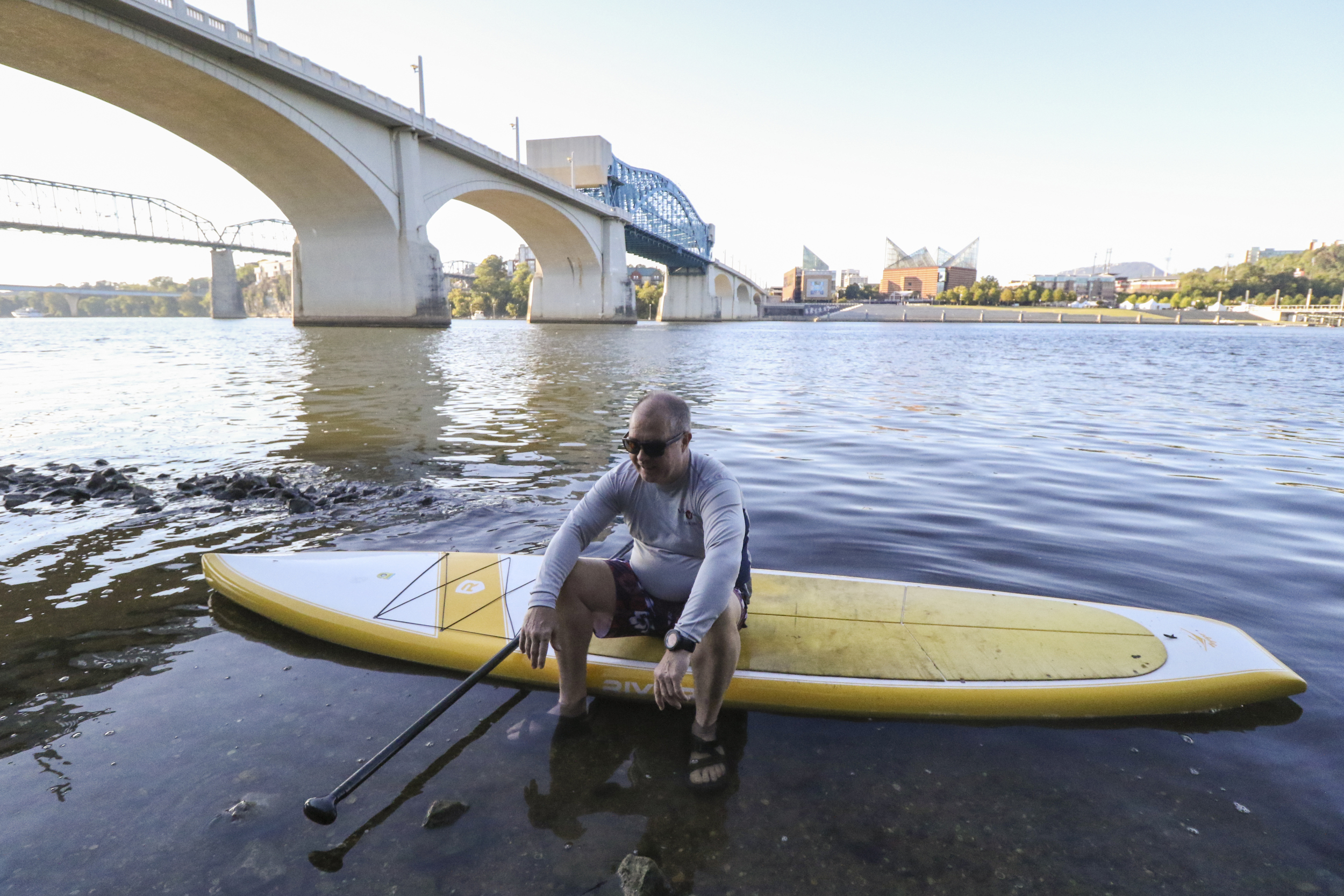 Staff Photo by Dan Henry / The Chattanooga Times Free Press- 9/29/16. Andy Parker returns to the Coolidge Park put-in under the Market Street Bridge after paddle boarding on the Tennessee River before work on Thursday, September 29, 2016.