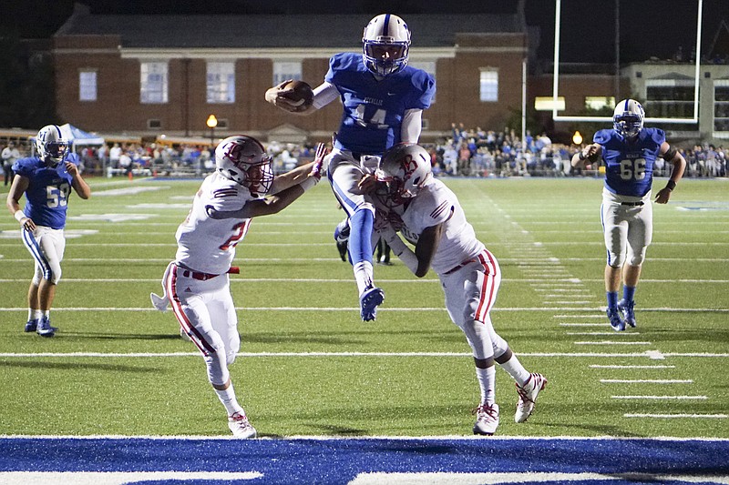 Staff Photo by Dan Henry / The Chattanooga Times Free Press- 9/30/16. McCallie's Robert Riddle (14) leaps over Baylor defenders Henry White (25) and Jaylon Baker (7) into the end zone before a penalty brings them back during the first half of play at the Blue Tornado's home field on September 30, 2016. 