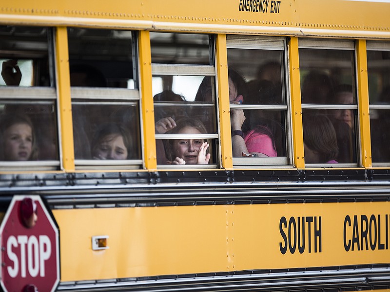A Townville Elementary student looks out of the window of a school bus as she and her classmates are transported to Oakdale Baptist Church, following a shooting at Townville Elementary in Townville Wednesday, Sept. 28, 2016. A teenager killed his father at his home Wednesday before going to the nearby elementary school and opening fire with a handgun, wounding two students and a teacher, authorities said. 