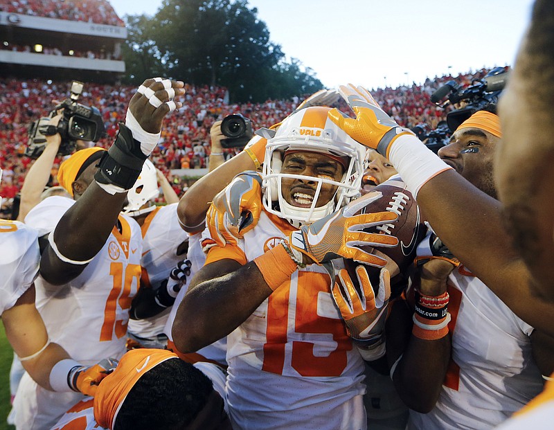 Tennessee wide receiver Jauan Jennings (15) is mobbed by his teammates after making a game-winning catch as time expired in the in the second half of an NCAA college football game against Georgia Saturday, Oct. 1, 2016, in Athens, Ga. Tennessee won 34-31. (AP Photo/John Bazemore)