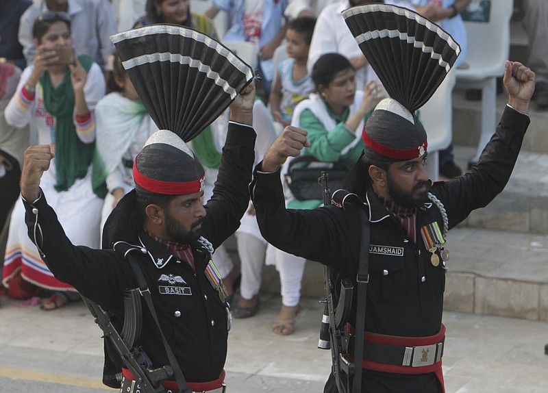 
              Pakistani border guards gesture while looking at their Indian counterpart during a daily border closing ceremony at sunset, at the Wagha border post, Pakistan, Saturday, Oct 1, 2016. A routine daily flag-lowering ceremony at an Indian-Pakistani border crossing has become a show of strength and patriotism on the Pakistani side thanks to simmering tensions between the two nuclear-armed neighbors. (AP Photo/K.M. Chaudhry)
            
